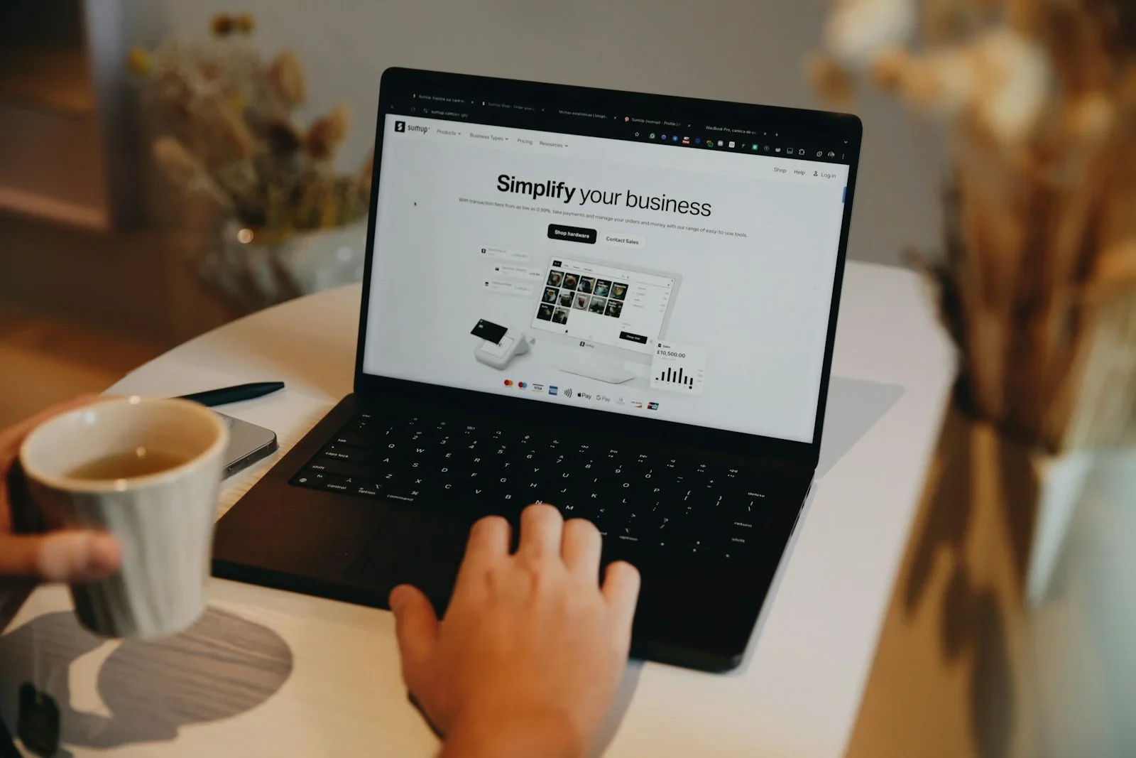 A person sitting at a table using a laptop computer